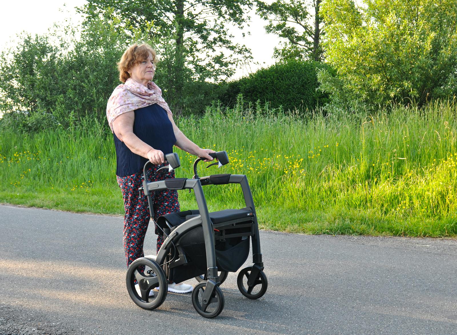 elderly woman walking with a rollator walker